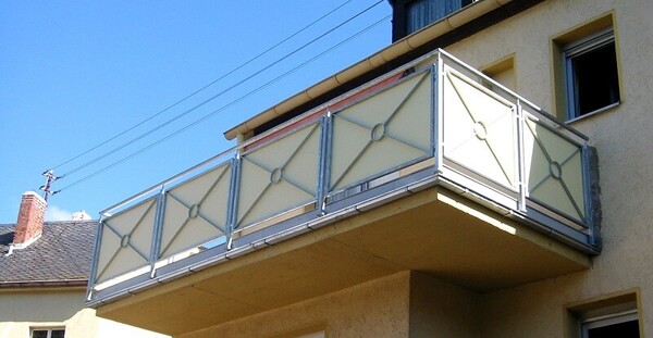 Moderner Balkon mit pulverbeschichtetem Aluminiumgeländer und Milchglasfüllungen am Haus